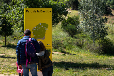 Dues persones miren el cartell de senyalització del parc