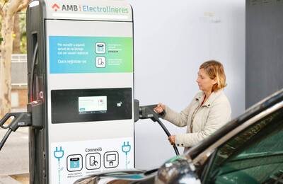 Dona recarregant el seu vehicle en una electrolinera metropolitana