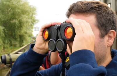 Persona amb uns prismàtics per a l'observació d'espècies d'ocells