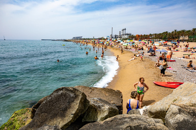 Persones banyant-se a la platja un dia d'estiu