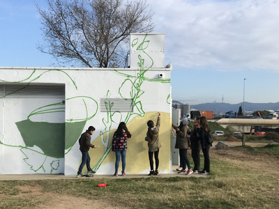 joves pintant el mural de la caseta d'eines