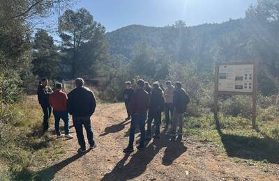 Representants fent una rotllana davant de Can Colomer i atenent l'explicació del tècnic de l'AMB