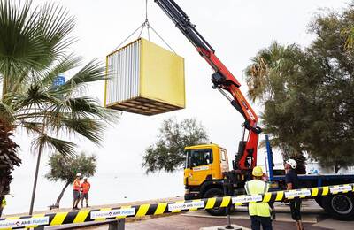 Grua retirant una dels mòduls de primers auxilis de la platja
