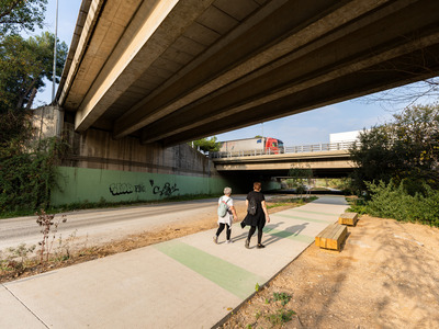 dos vianants pel camí sota un pont