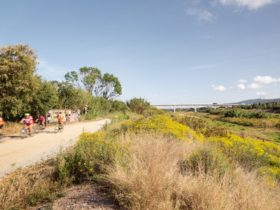 ciclistes pel camí vora el riu