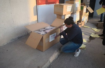 Un home prepara unes caixes amb productes de primera necessitat per a infants