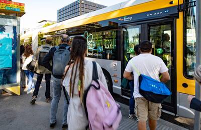 Usuaris del transport públic pujant a un bus metropolità