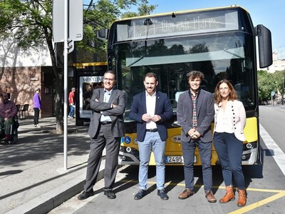 Personal tècnic i polític davant d'un autobús presentant l'ampliació de la cobertura