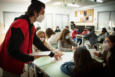 L'educador reparteix les fitxes de l'activitat